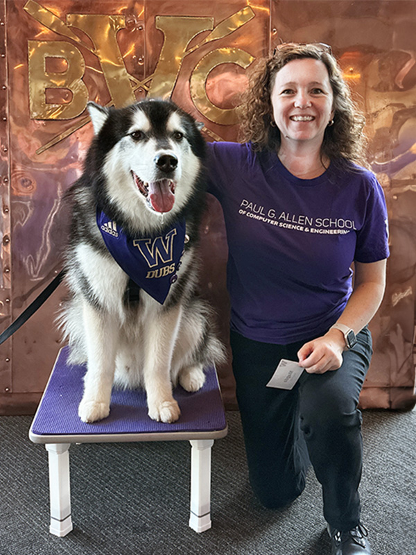 2024 Portrait of Magdalena Balazinska with her arm around Dubs, the UW Huskies' mascot, in front of a shiny copper backdrop